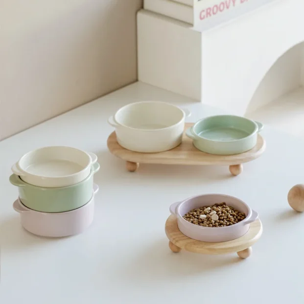 Ceramic elevated pet bowl set with wooden stand on kitchen floor